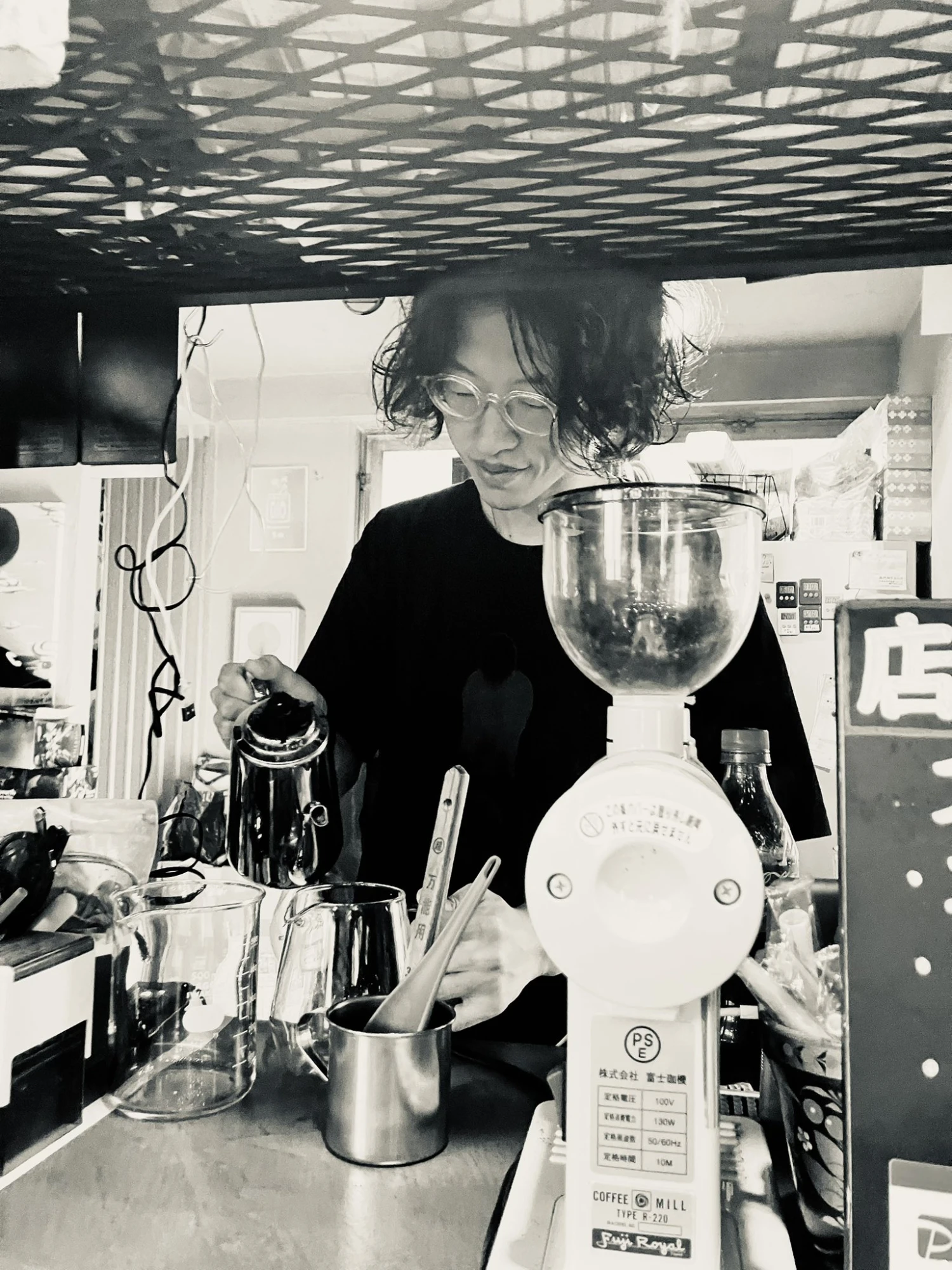 高円寺ケムリバでの出張コーヒーイベントで焙煎士ファルコンさんがコーヒーを淹れる様子（富士ローヤルのミルとともに）