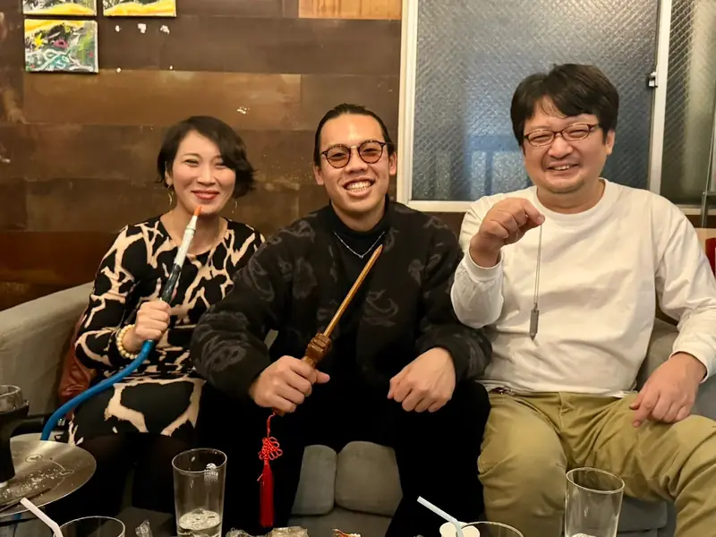 ソファ席でシーシャを囲んで笑う3人