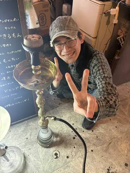 シーシャの横でピースするスタッフ
