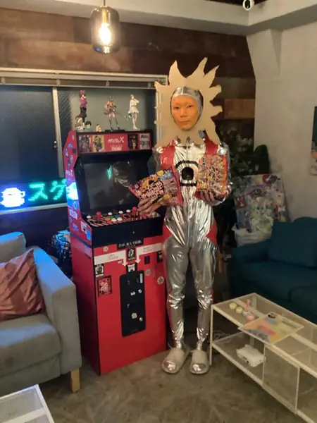 着ぐるみ姿でゲーム筐体の前に立つスタッフ