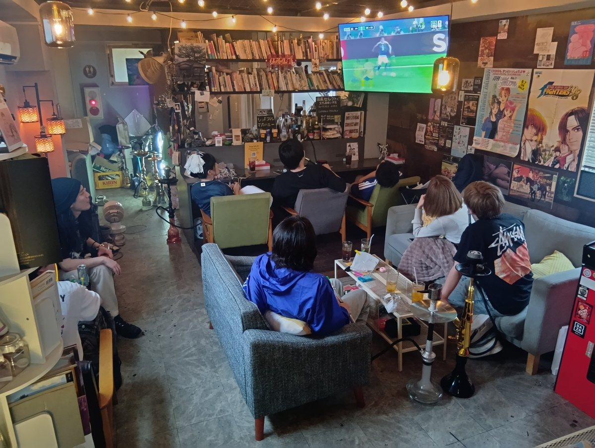 高円寺ケムリバのパブリックビューイングで大型モニターのサッカー観戦を楽しむ店内の様子